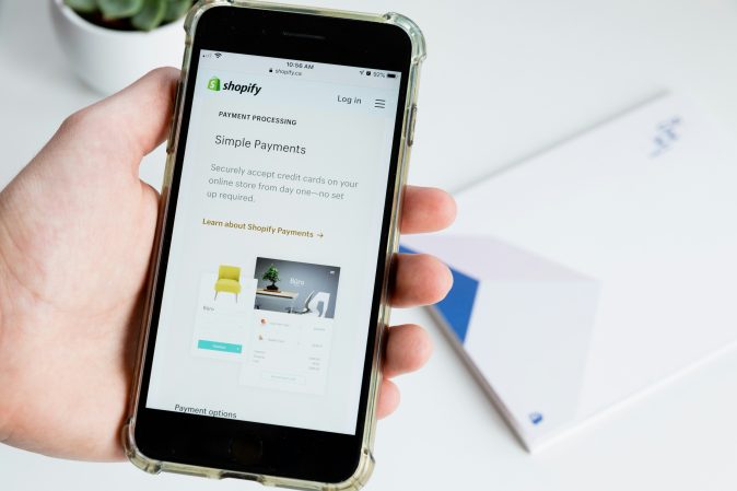 hand holding an iPhone showing a Shopify website